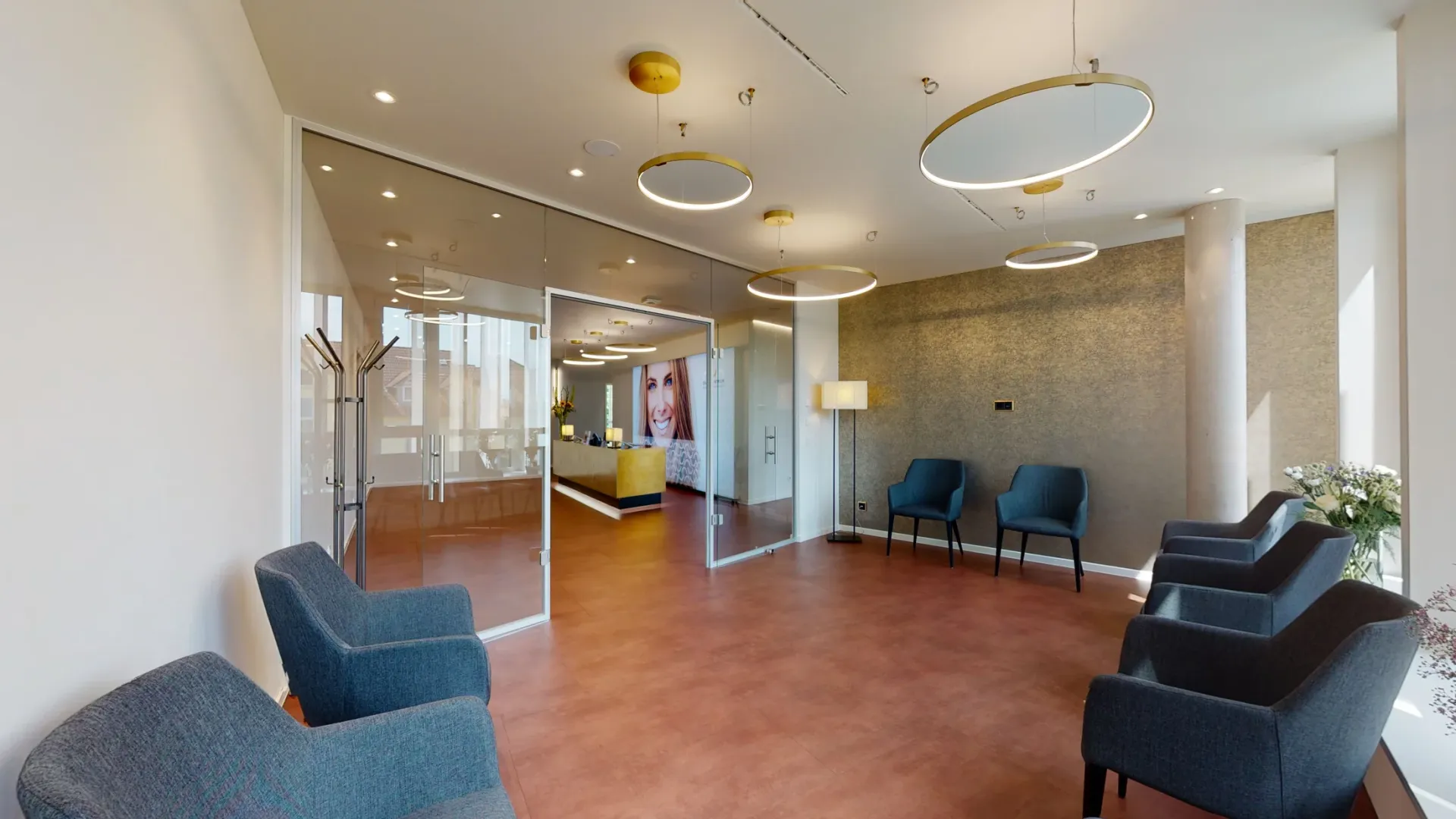 Wartezimmer mit goldener Wandgestaltung und braunem Boden.